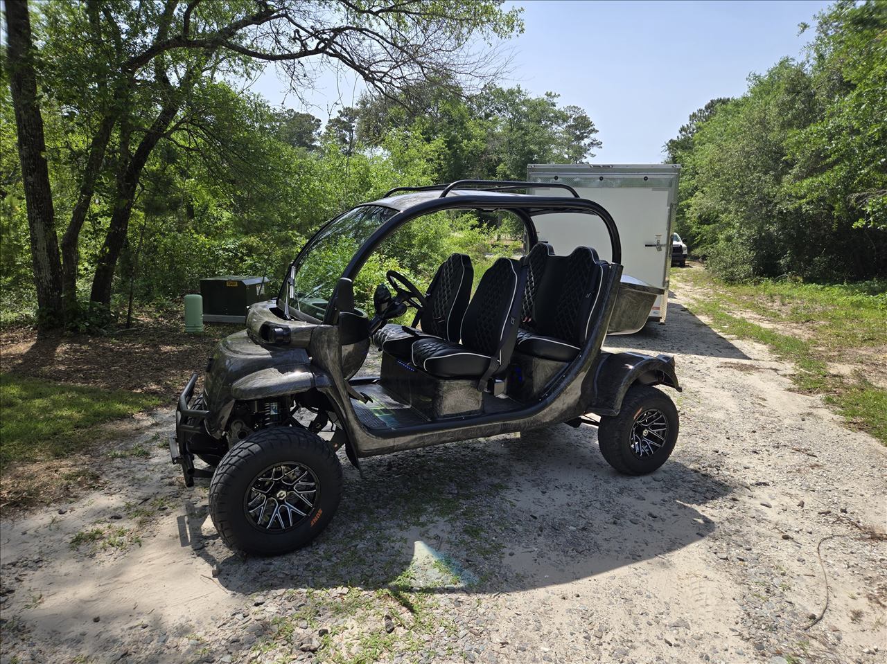 Custom four-seat GEM cart with lifted suspension and diamond-stitched seating